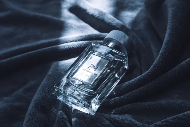 شیشه‌ی عطر روی پارچه‌ی تیره