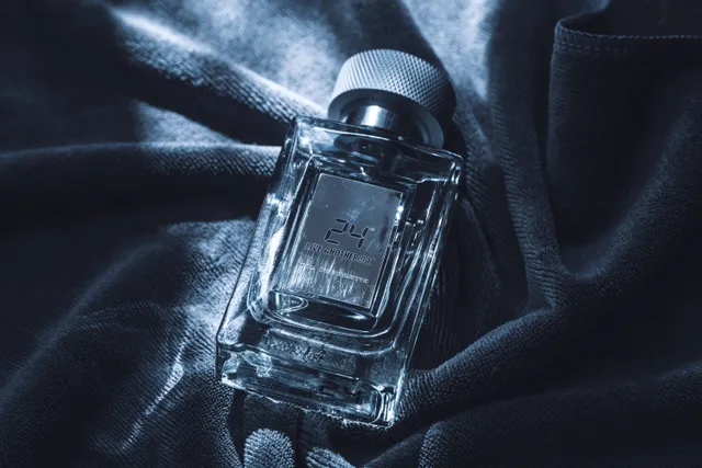 شیشه‌ی عطر روی سطح تیره